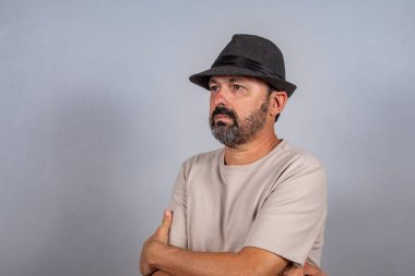 Çekici, olgun bir adamın portresi. Gri arka planda izole edilmiş bej gömlek giyen gerçek mutlu duygular hisset.