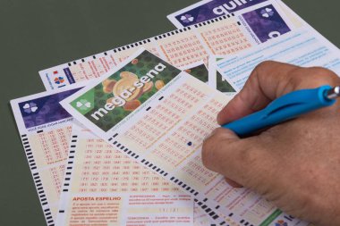 Rio, Brazil - July 20, 2022: person filling out Caixa Economica Federal lottery card, the only official betting method in Brazil