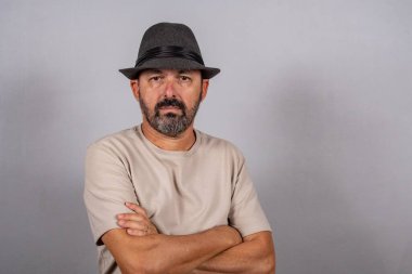 Çekici, olgun bir adamın portresi. Gri arka planda izole edilmiş bej gömlek giyen gerçek mutlu duygular hisset.