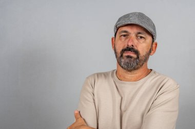 Çekici, olgun bir adamın portresi. Gri arka planda izole edilmiş bej gömlek giyen gerçek mutlu duygular hisset.