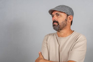 Çekici, olgun bir adamın portresi. Gri arka planda izole edilmiş bej gömlek giyen gerçek mutlu duygular hisset.