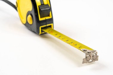 Beyaz arkaplanda izole edilmiş küçük boşlukları ölçmek için sarı mezura
