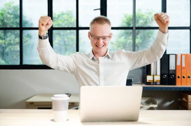 İş adamı online başarı kutlaması yapıyor, başarı elde ediyor, genç adam iyi e-posta haberlerinden memnun, büyük bir teklifle veya yeni bir fırsatla motive oluyor.