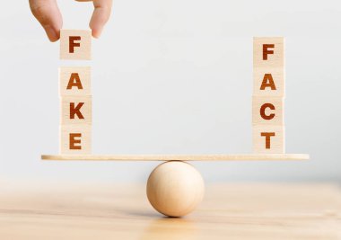 Gerçek mi, sahte mi? Tahta küp blok ile kelime ile Gerçek ve Sahte tahterevalli üzerinde