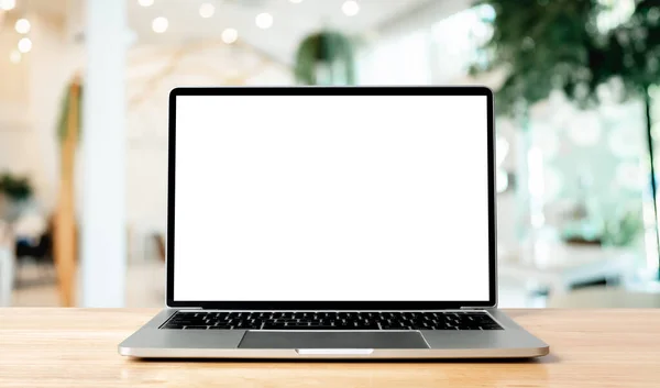 Ahşap masadaki laptop boş ekran bulanık kahve dükkanının iç fonu ve aydınlatma bokeh, model, metin için şablon, arka plan ve aygıt ekranı için kırpma yolları dahil