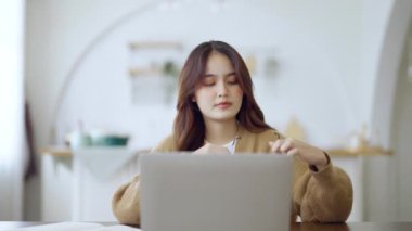 Ofis sendromu konsepti. Çok çalışan yorgun Asyalı kadın baş ağrısı çekiyor, bilgisayardan sonra görme sorunu yaşıyor. Evde yorgunluk çeken stresli bir iş kadını.