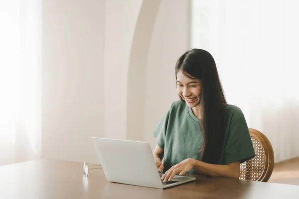 微笑着在总公司的笔记本电脑上工作的亚洲年轻女人 利用计算机远程学习 虚拟培训 电子学习 在家观看网上教育研讨会的年轻亚洲学生 — 图库照片