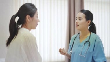 Muayene odasında hastayı rahatlatan kadın doktorun eli. Kadın doktor ve hasta hastalığın semptomları hakkında görüşmeler yapıyorlar.