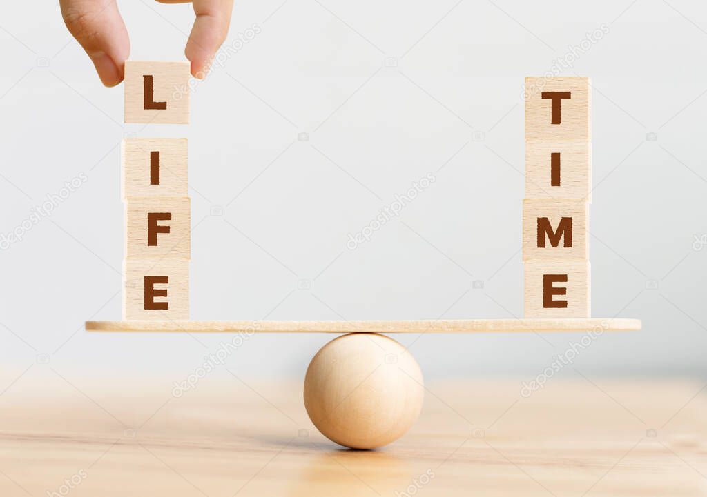 Life time balance concept. Wooden cube block with word LIFE and TIME on seesaw