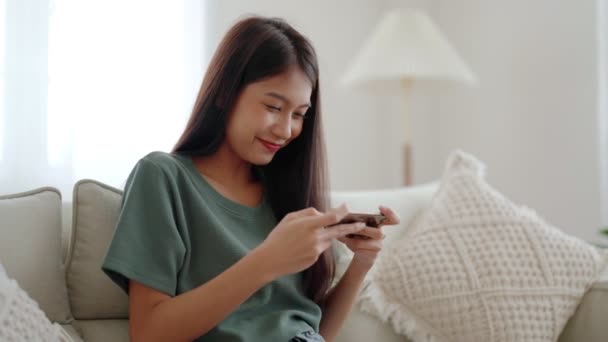 Feliz Joven Asiática Mujer Relajarse Cómodo Sofá Casa Jugando Juegos — Vídeo de stock