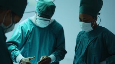 Ameliyathane ekibi ameliyathanede. Doktor ve hemşire planlama ameliyatını tartışıyor