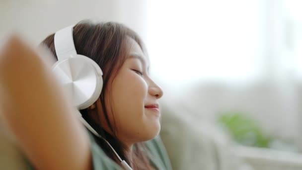 Νεαρή Ασιάτισσα Που Ακούει Μουσική Στον Καναπέ Στο Σαλόνι Στο — Αρχείο Βίντεο