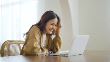 Heyecanlı Asyalı kadın mutlu bir şekilde çevrimiçi zaferi kutluyor. Başarı başarısı, iyi e-posta haberlerinden mutlu olan genç kadın, büyük bir teklifle ya da yeni bir fırsatla motive oluyor, sınavı geçiyor, işe giriyor.