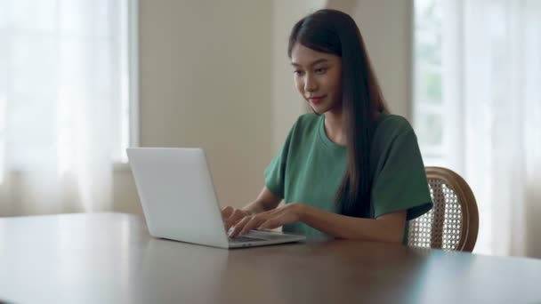 在家里工作的年轻亚洲女人 女性在家中桌上使用电脑笔记本电脑 — 图库视频影像