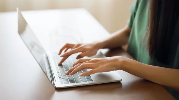 在家里用笔记本电脑键盘打字的妇女的手 — 图库照片