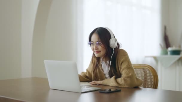 헤드셋을 아시아인 집에서 컴퓨터 랩탑으로 일하고 있습니다 집에서 일하고 비디오 — 비디오