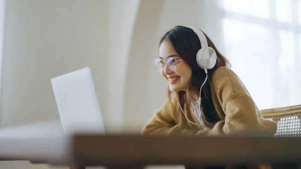 Young asian woman wearing glasses and headset working on computer laptop at house. Work at home, Video conference, Video call, Student learning online class
