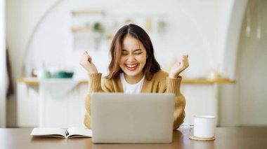 Heyecanlı Asyalı kadın mutlu bir şekilde çevrimiçi zaferi kutluyor. Başarı başarısı, iyi e-posta haberlerinden mutlu olan genç kadın, büyük bir teklifle ya da yeni bir fırsatla motive oluyor, sınavı geçiyor, işe giriyor.
