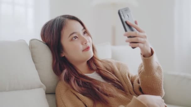 Gelukkig Jong Aziatisch Vrouw Ontspannen Comfortabele Bank Thuis Sms Smartphone — Stockvideo