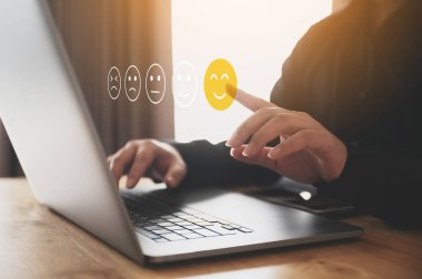 Müşteri hizmetleri tecrübesi ve iş memnuniyeti anketi. Bilgisayarı kullanan erkek el, gülümsemeyi seç.