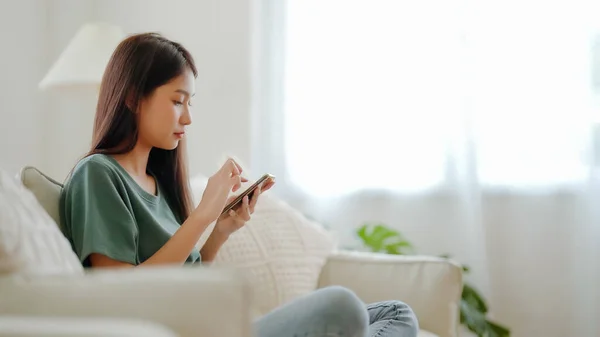 Gelukkig Jong Aziatisch Vrouw Ontspannen Comfortabele Bank Thuis Sms Smartphone — Stockfoto