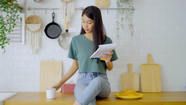Een Gelukkige Jonge Aziatische Vrouw Die Thuis Keuken Zit Vrouwelijke — Stockvideo