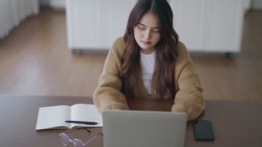 Ofis sendromu konsepti. Çok çalışan yorgun Asyalı kadın baş ağrısı çekiyor, bilgisayardan sonra görme sorunu yaşıyor. Evde yorgunluk çeken stresli bir iş kadını.