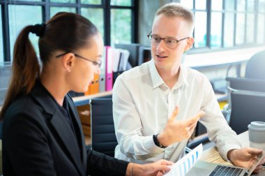 İş adamı ve iş kadını proje planlama kurumuyla tanışıyor. İki iş adamı çalışmayı tartışıyor.