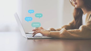 Ahşap masada bilgisayar kullanan bir kadın. Uygulama iletişimi dijital medya web sitesi ve sosyal ağ üzerinden çevrimiçi ileti canlı sohbet