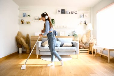 Ev temizliği ve eğlence. Temizlik sırasında en sevdiği şarkıyı söyleyen Asyalı genç ev kadını mikrofon olarak paspası kullanıyor, ev işlerinden zevk alıyor. Genç bir kadın oturma odasında dans edip temizlik yapıyor.