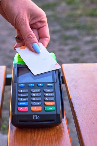 Close-up of a credit card and a payment terminal. Contactless bank card with NFC technology. Payment with the terminal