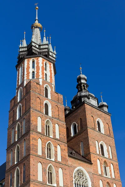 Dos torres de la Basílica de Santa María en el principal sguare del mercado en Cracovia en Polonia sobre fondo azul del cielo — Foto de Stock