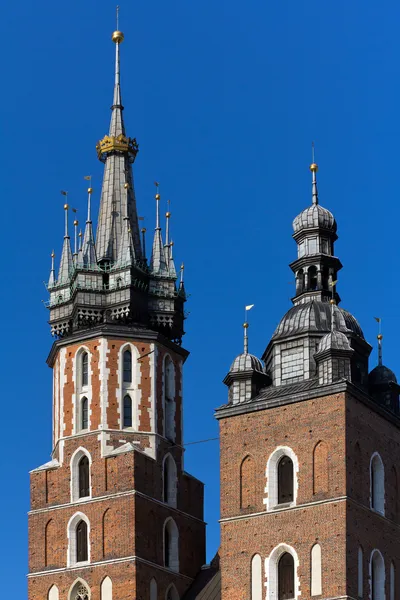 Дві вежі Маріацького на трьохярусними головний ринок у Кракові у Польщі на фоні синього неба — стокове фото