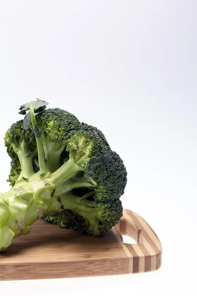 Fresh broccoli on the cutting board on white background — Stock Photo, Image