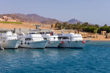 Dahab, Mısır - 10 Eylül 2021: limana demirlemiş dalış botlarının görüntüsü. Dahad eski bir Bedevi köyü, şimdi Mısır 'ın en değerli dalış alanlarından biri.