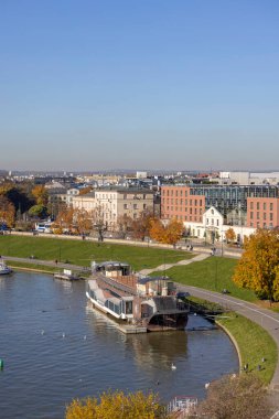 Krakow, Polonya - 25 Ekim 2021: Wisla nehri üzerindeki bulvar, sakinler ve turistler için dinlenme alanı, kıyıya demir atmış bir restoran.