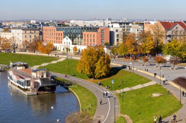 Krakow, Polonya - 25 Ekim 2021: Wisla nehri üzerindeki bulvarlar, bölge sakinleri ve turistler için eğlence alanı, kıyıya demir atmış bir restoran.