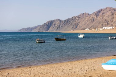 Dahab, Mısır - 10 Eylül 2021: Kızıldeniz manzarası ve limana demirlemiş tekneler. Dahad, dağlarla çevrili eski bir Bedevi köyü. Şimdi Mısır 'ın en değerli dalış alanlarından biri.