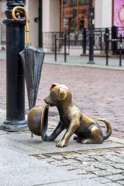 Torun, Polonya - 27 Haziran 2020: Filus ve Profesör Filutek, Polonyalı hicivci Zbigniew Lengren 'in hicivci hikayelerindeki çizgi film karakterlerinin metal figürü. Sahibini bekleyen bir köpek.