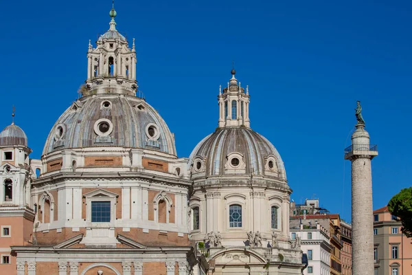 意大利罗马 在蓝天背景下的特拉扬论坛的特拉扬圆柱 圣玛丽亚 洛雷托教堂和圣母玛利亚教堂的圆顶景观 — 图库照片