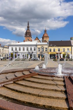 Nowy Sacz, Polonya - 30 Ağustos 2022: çeşmeli Pazar Meydanı manzarası. Polonya 'nın güneyindeki Küçük Voyvoda' da bir şehirdir. Arka planda St. Malgorzata Kolej Bazilikası 'nın kuleleri var.