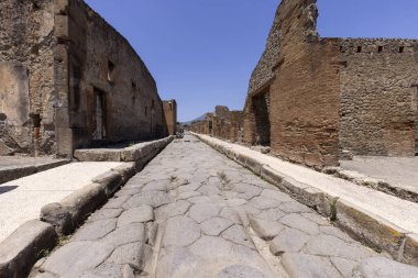 Pompeii, Napoli, İtalya - 26 Haziran 2021: M.S. 79 'da Napoli yakınlarında Vesuvius volkanının patlaması sonucu yıkılan antik bir şehrin kalıntıları. Şehir sokaklarından birinin manzarası