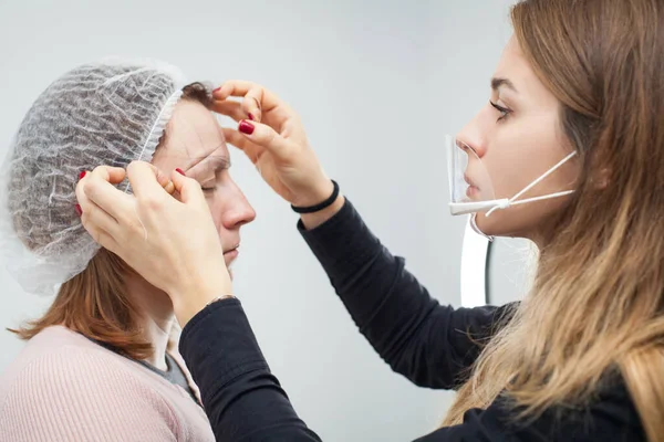 Kalıcı makyaj, kaş dövmesi. Usta bir iplikle çizgiler çizer, kaşların resmini çizer.