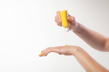 Beyaz arka planda bir kadın eli. Krema, sarı geyik deride.