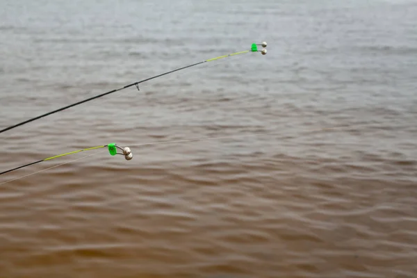 Oltaya takılmış bir zil. Olta ipi. Balık oltası. Nehir Görünümü.