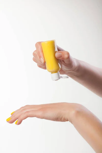 Beyaz arka planda bir kadın eli. Krema, sarı geyik deride.