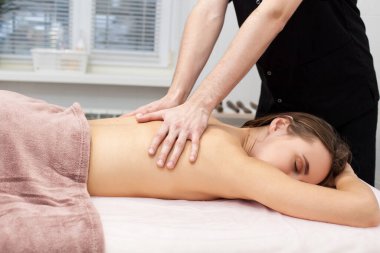 Yakından güzel bir kadın boyun masajı yaptırıyor. Yan görünüm 