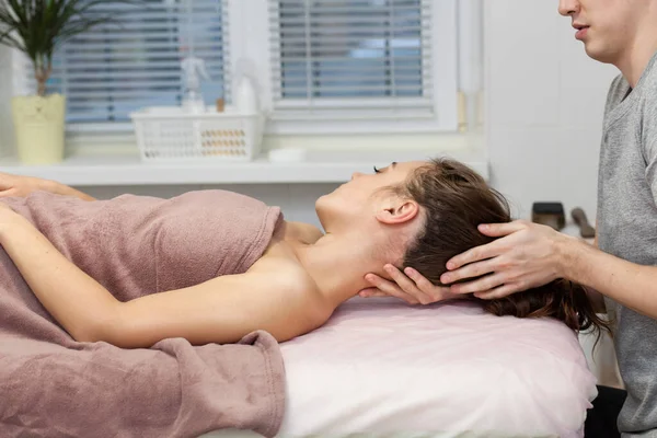 Yakından güzel bir kadın boyun masajı yaptırıyor. Yan görünüm