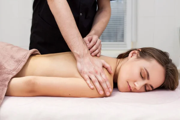 Yakından güzel bir kadın boyun masajı yaptırıyor. Yan görünüm 