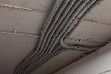 Kaburganın tavanında elektrik kabloları üretiyor.